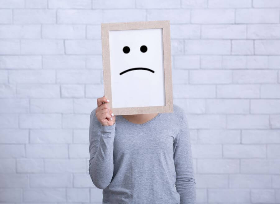 woman holding a sad face icon