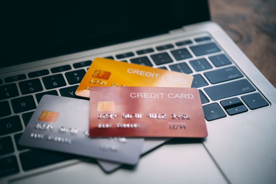 Close up multiple credit cards placed on a laptop